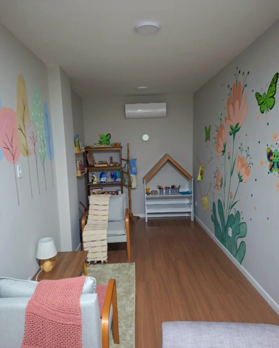 Sala de espera acolhedora do consultório de Débora Peres, com decoração lúdica para crianças, em Rio das Ostras